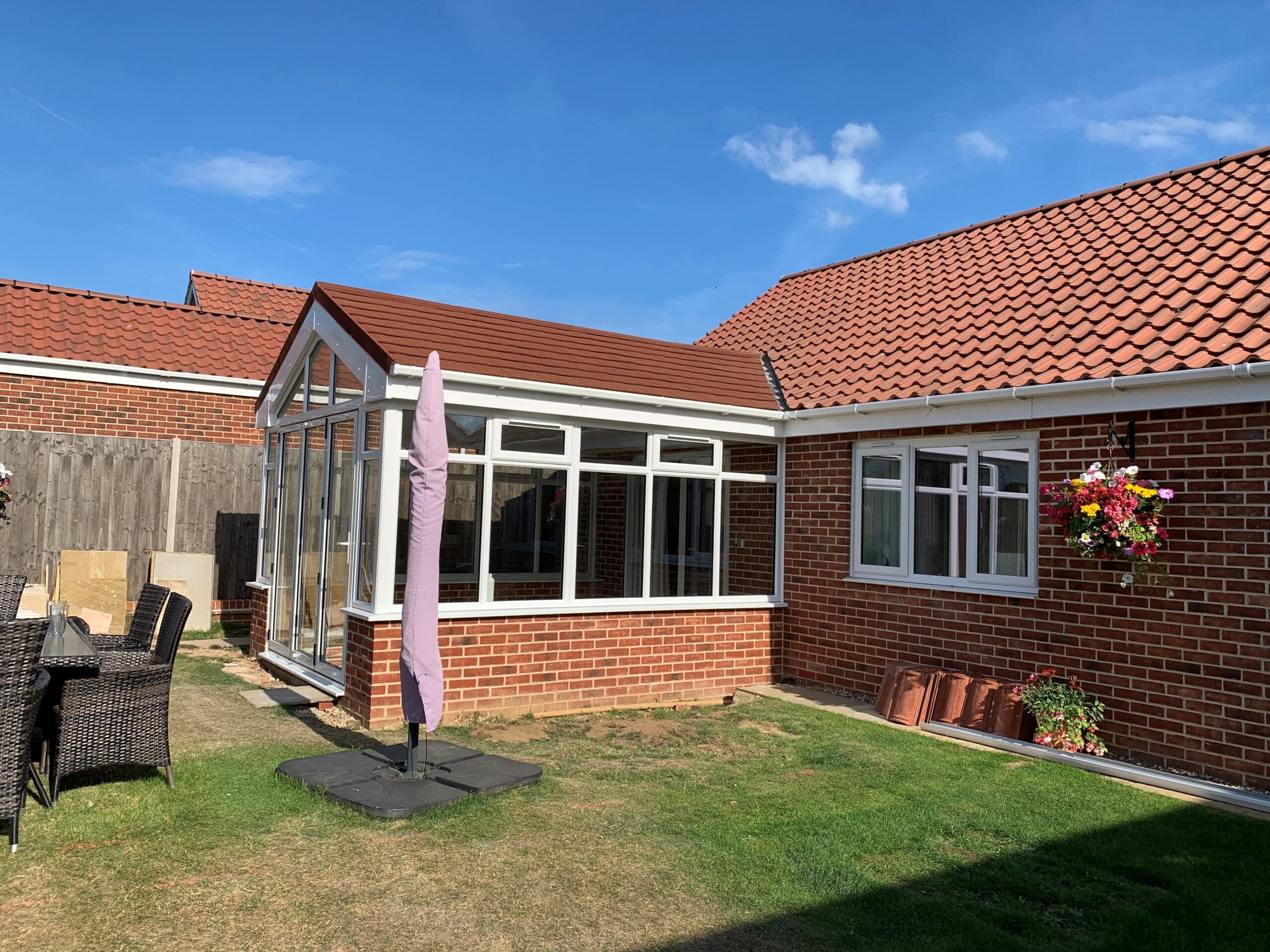 BBC 12408 (5) | Insulated Conservatory Company | Insulated Conservatory Company Bungalow with a white framed insulated conservatory and tiled roof overlooking a lawn