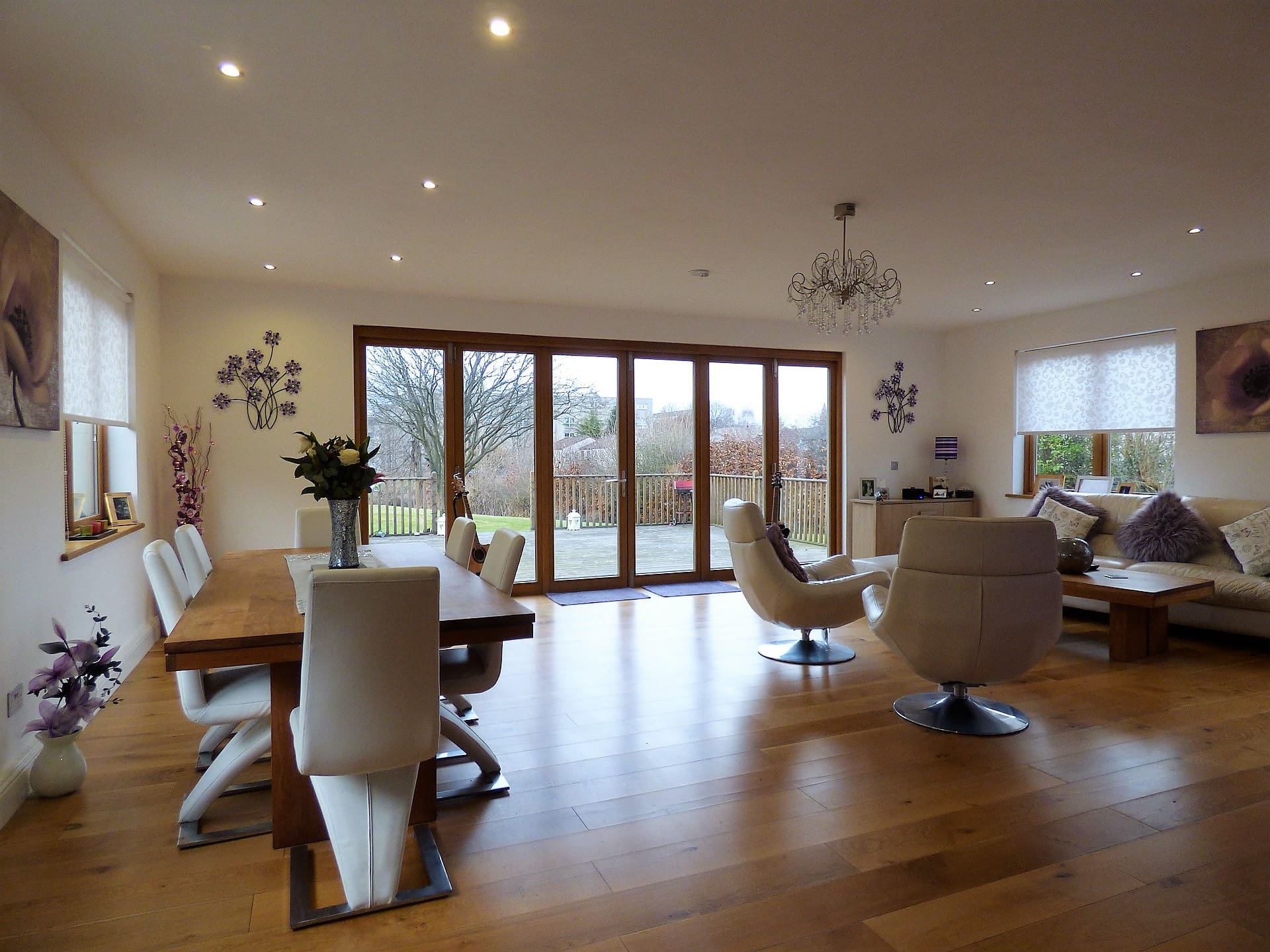 Bi-fold doors | Insulated Conservatory Company | Insulated Conservatory Company Dining room with wide bi-fold doors opening onto a coastal view