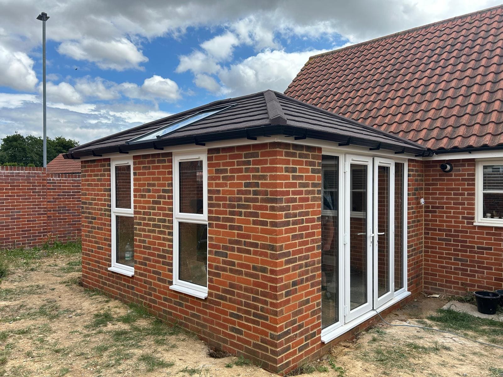 IMG-20250808-WA0009 | Insulated Conservatory Company | Insulated Conservatory Company Small brick garden room extension with a tiled roof and white windows