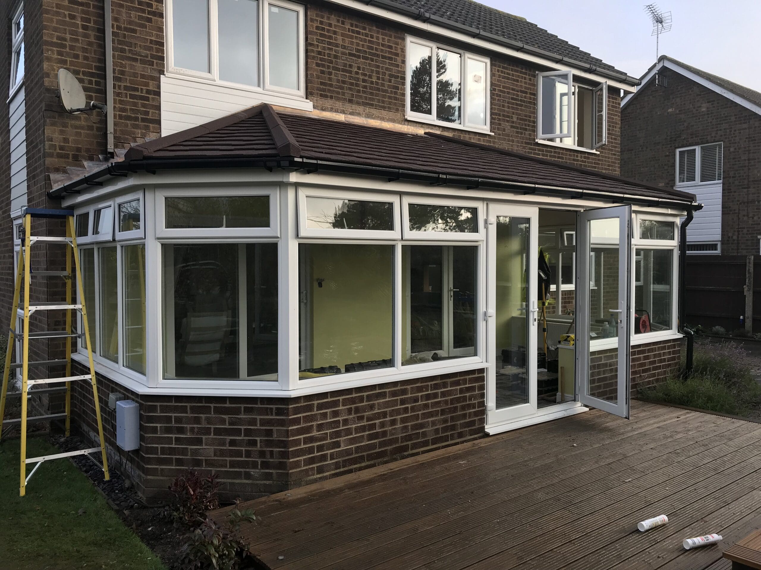 Conservatory with a non standard solid roof being fitted to a brick house